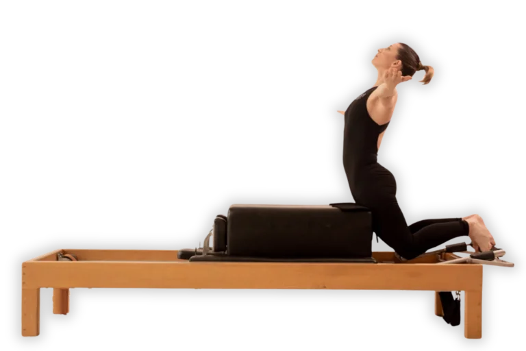 Practicante de Pilates arrodillada sobre un reformer